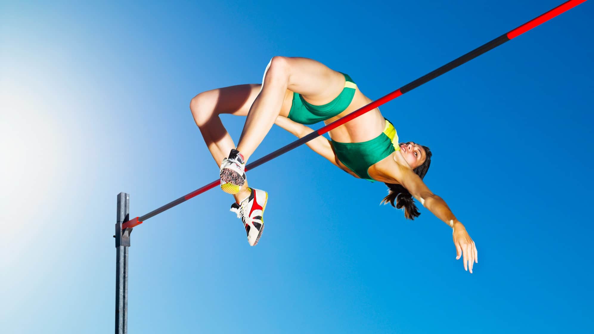 Female high jumper clears bar
