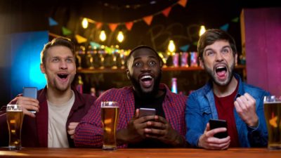 3 men at bar betting on sports online 16.9