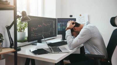 man with head in hands after looking at stock market crash on computer, asx 200 share market crash