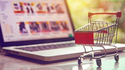 asx online retail share price represented by shopping trolley next to laptop