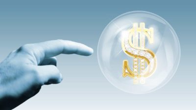hand about to burst bubble containing dollar sign, asx shares, over valued