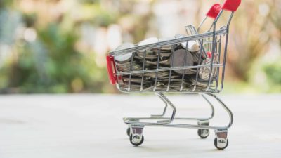 shopping trolley filled with coins representing asx retail share price.ce