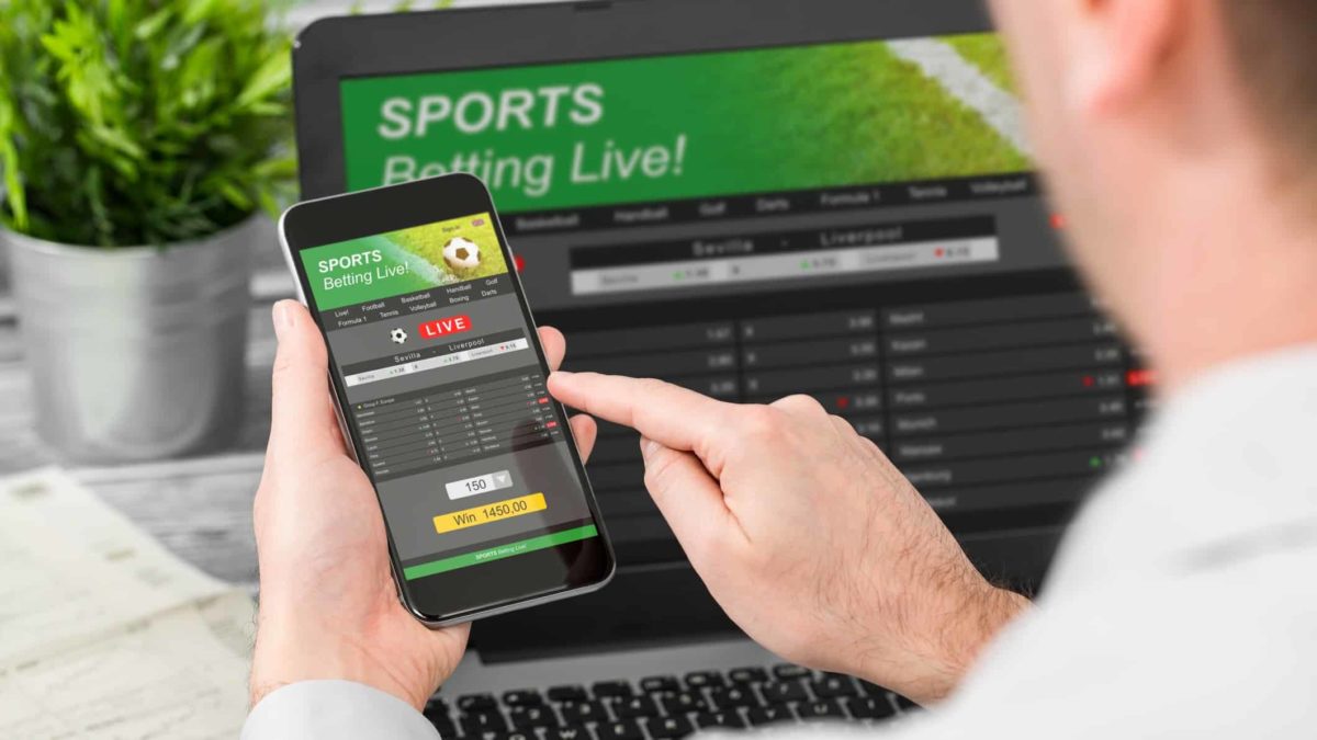 man placing sports bet on mobile phone and laptop, sports betting, pointsbet share price