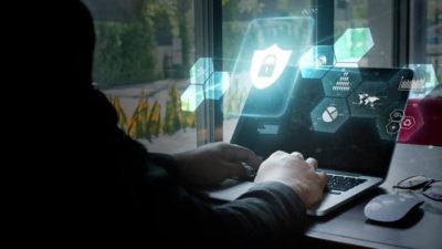 Man on laptop with cybersecurity symbols