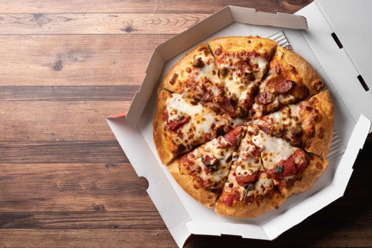 Image of home delivery pizza in a paper box signifying Domino's share price