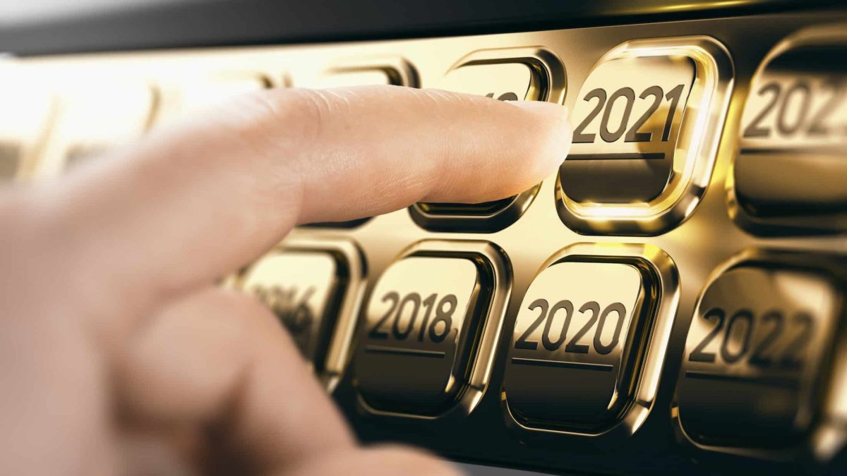 finger reaching out to press gold button entitled 2021