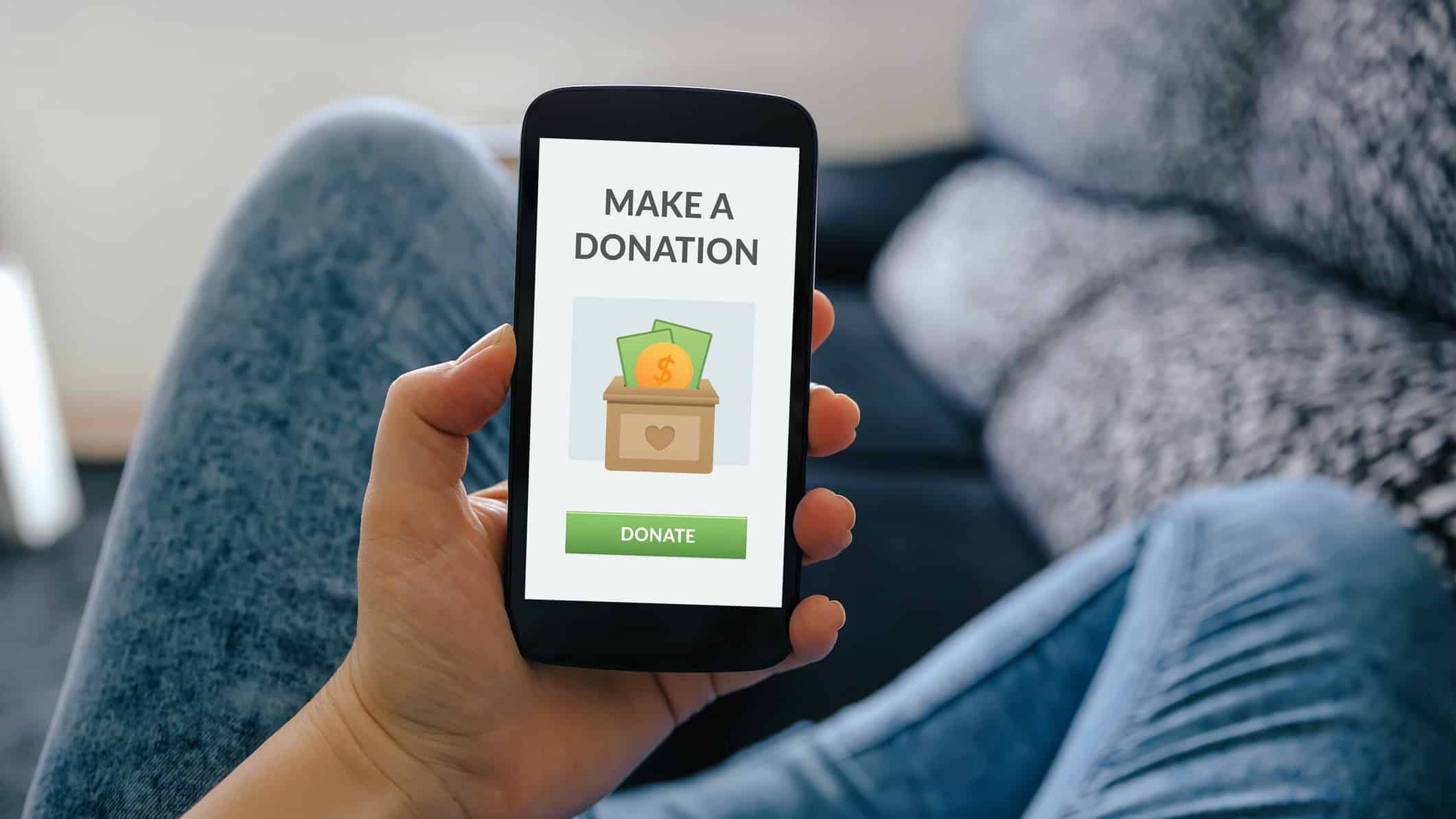 man holding mobile phone that says make donation