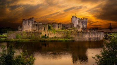 Castle surrounded by protective moat with sunset