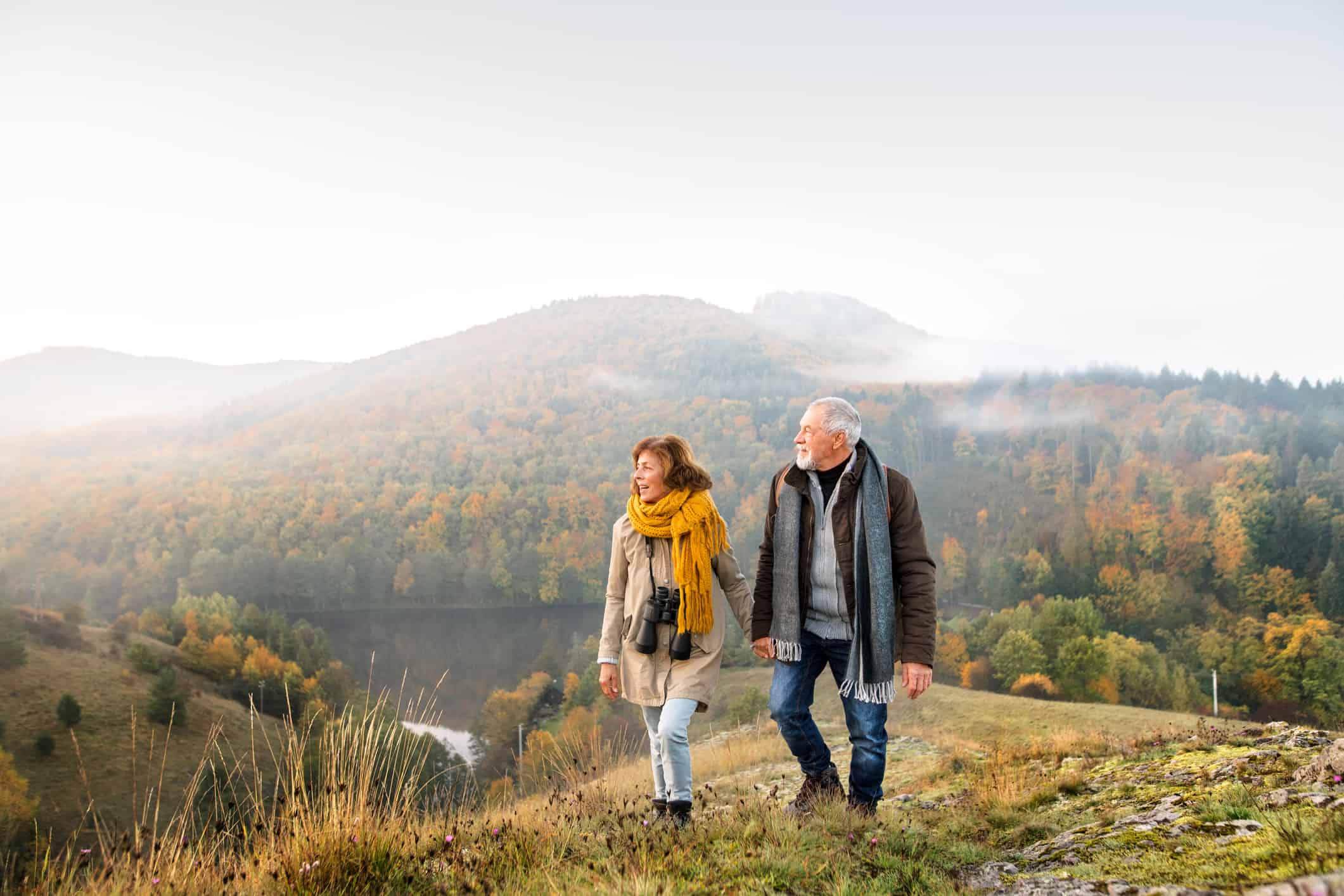 Active senior couple on a walk in a beautiful autumn nature.