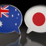 Japan and Australia flags in speech bubbles on black background