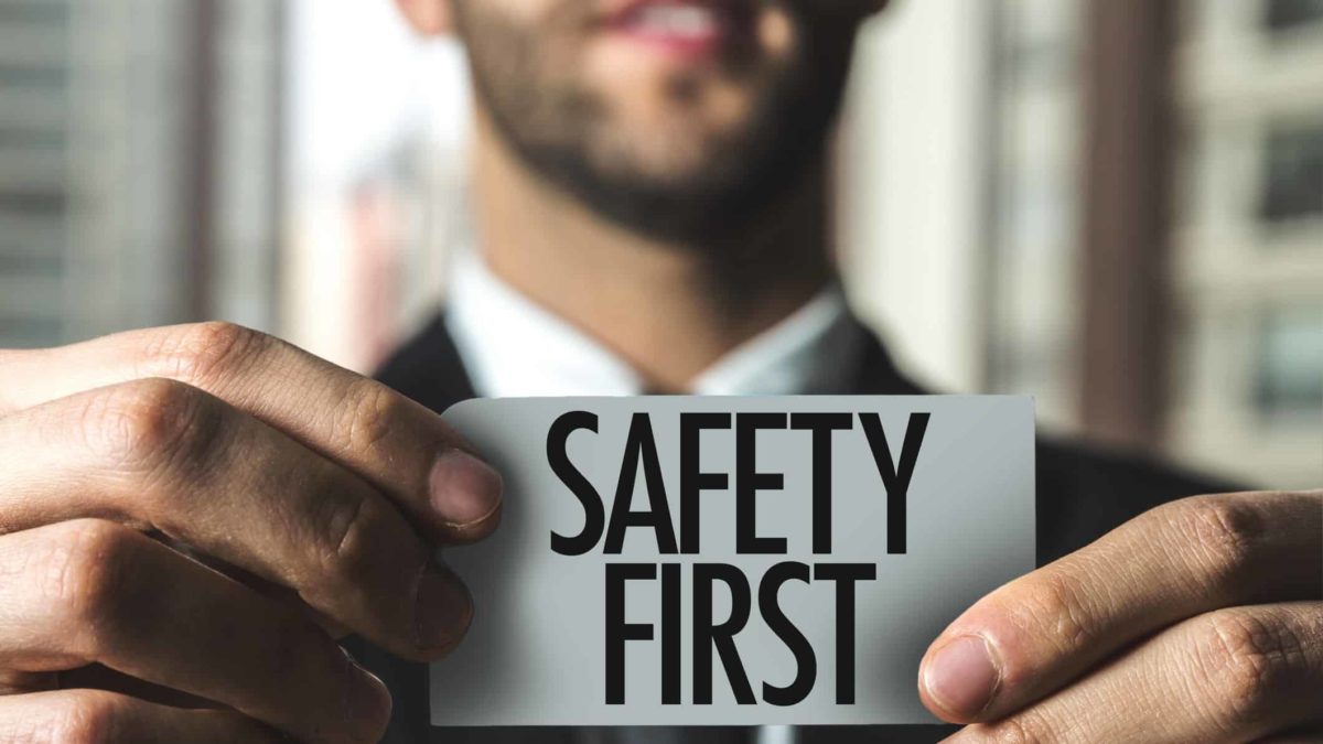 man holding sign that says safety first