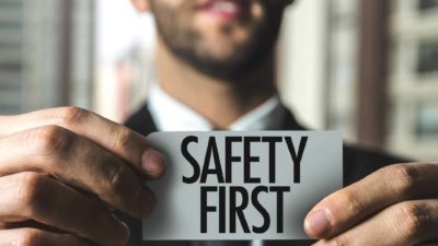 man holding sign that says safety first