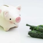 piggy bank next to miniature army tank