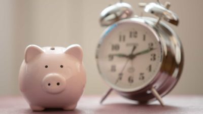 piggy bank next to alarm clock