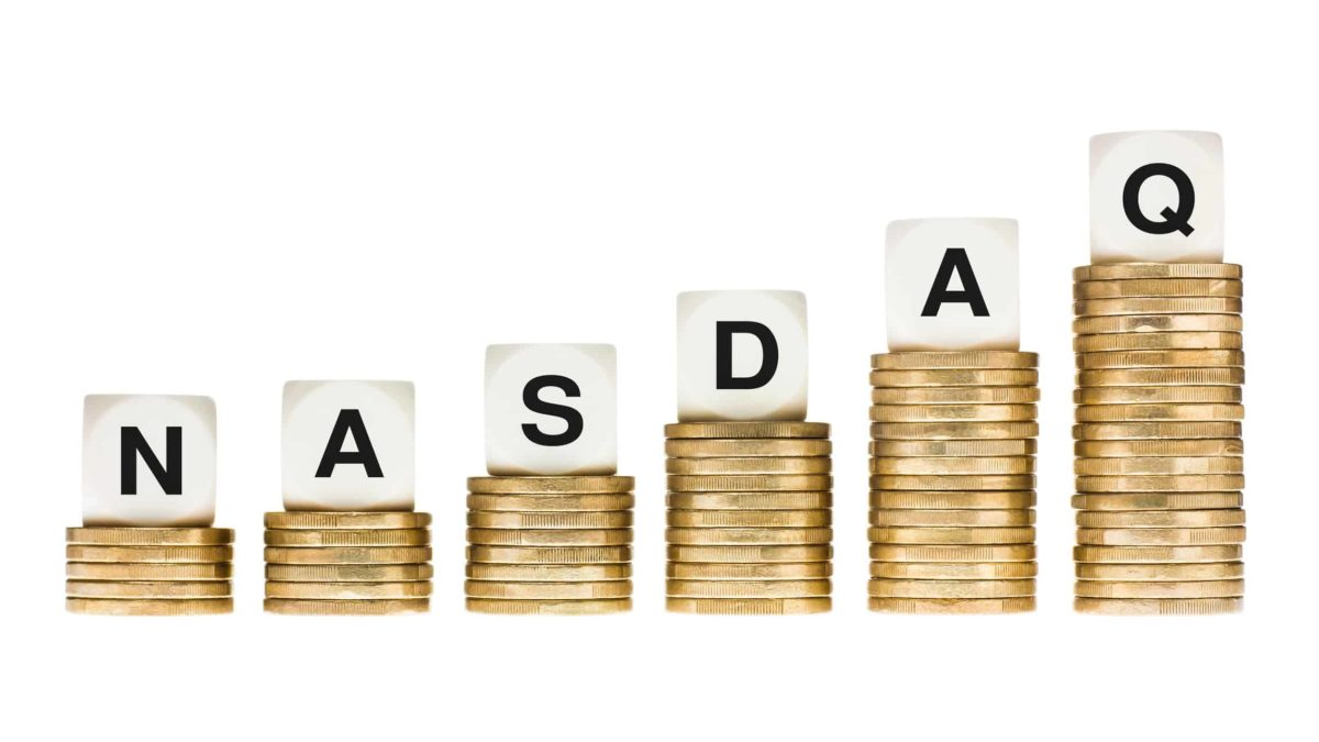 dice on top of piles of coins spelling the word nasdaq