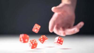 Gaming ASX share price represented by hand throwing four red dice