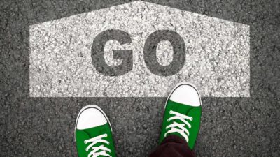 pair of shoes standing on concrete with go sign representing accent share price on watch