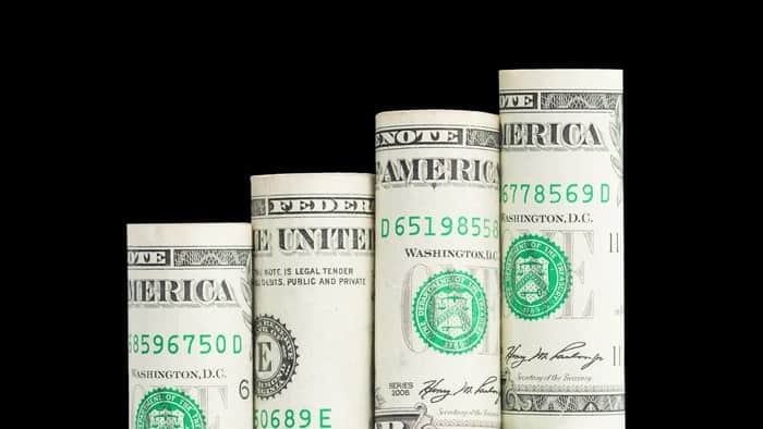 row of rolled up US banknotes increasing incrementally