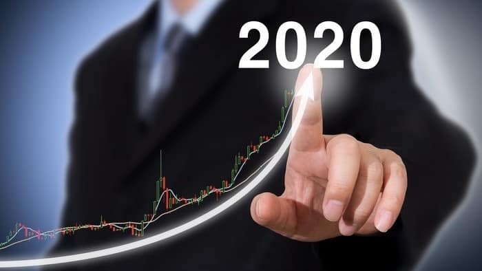 man touching digitised chart of rising arrow towards 2020