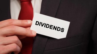 man placing business card in pocket that says dividends signifying asx dividend shares