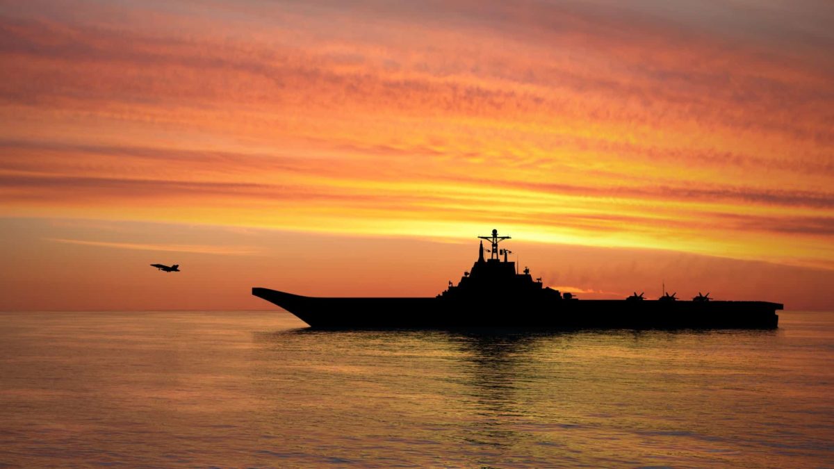 naval ship on the water at sunset