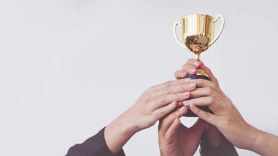 hands holding up winner's trophy