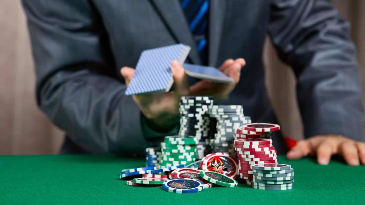 man playing cards with casino chips representing crown share price