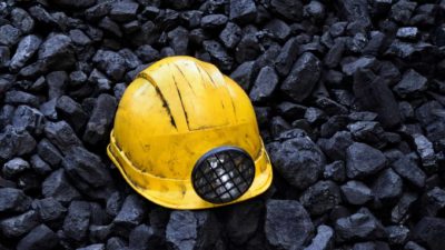 mining hat on lumps of coal representing mineral resources share price