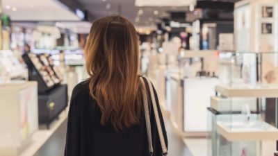 woman looking around and watching department store, such as Myer