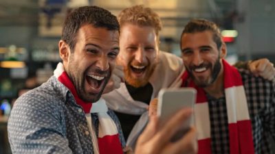 Sports fans looking at smart phone representing surging pointsbet share price
