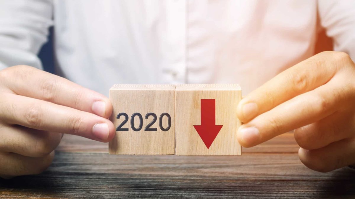 man holding wooden blocks with red down arrow and 2020 on them representing falling South32 share price