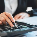 business man reviewing report and using calculator