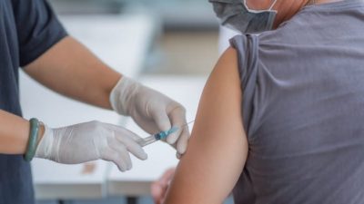 Patient wearing mask gets COVID vaccine injection