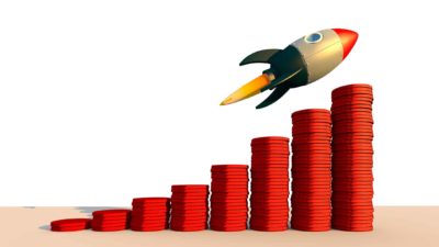 rising asx share price represented by rocket ascending increasing piles of coins