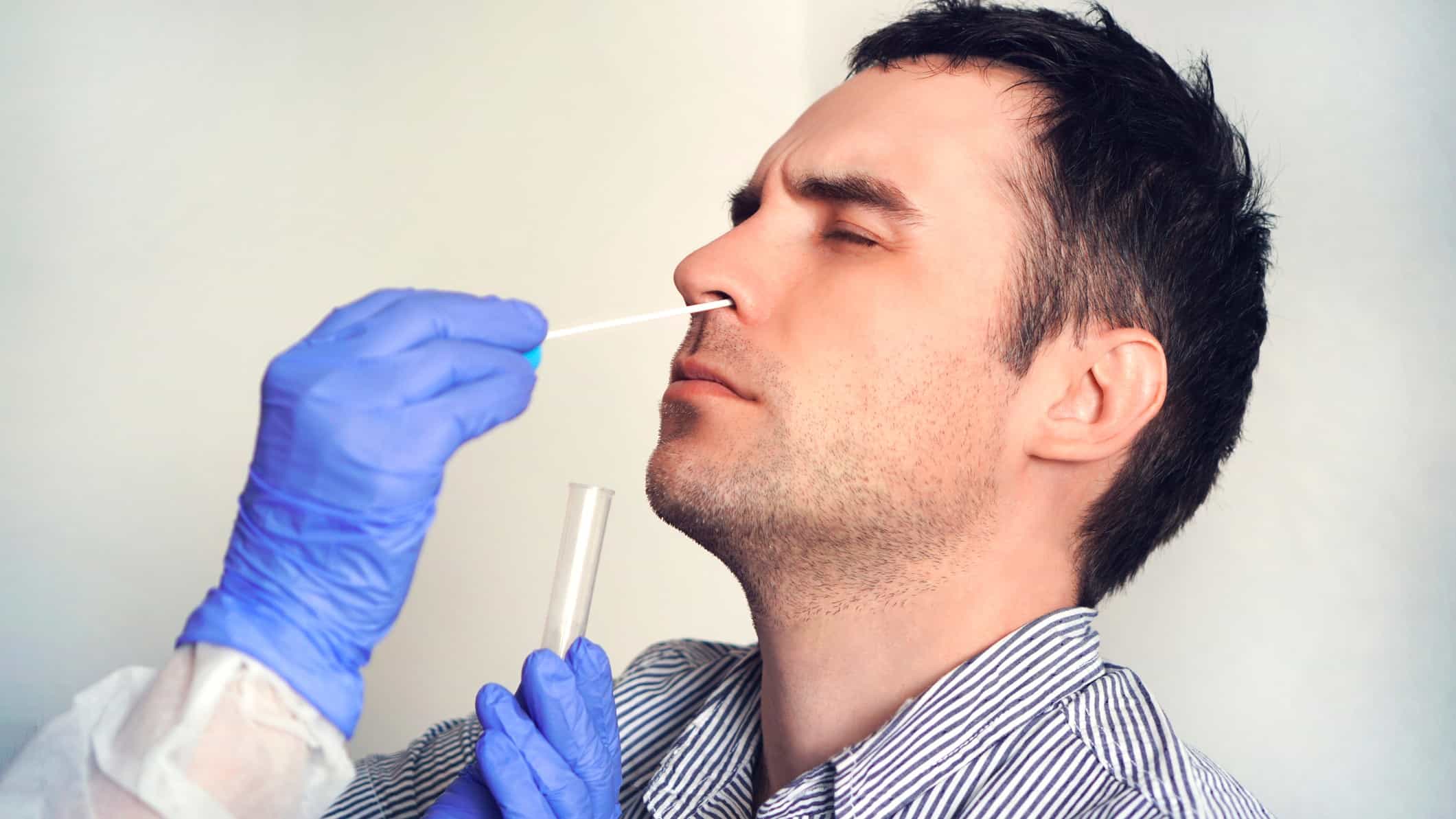 Sonic Healthcare share price represented by man receiveing nasal swab from medical professional