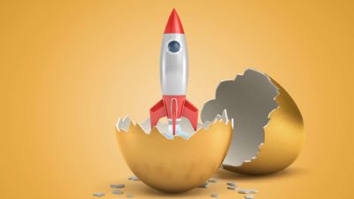 miniature rocket breaking out of golden egg representing rocketing share price
