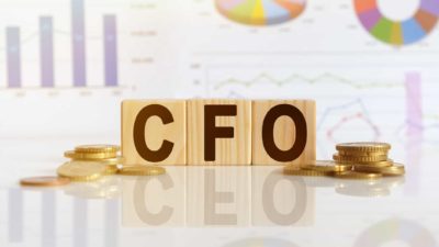 wooden blocks spelling out CFO surrounded by gold coins