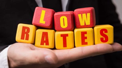 hand holding wooden blocks that spell 'low rates' representing low interest rates