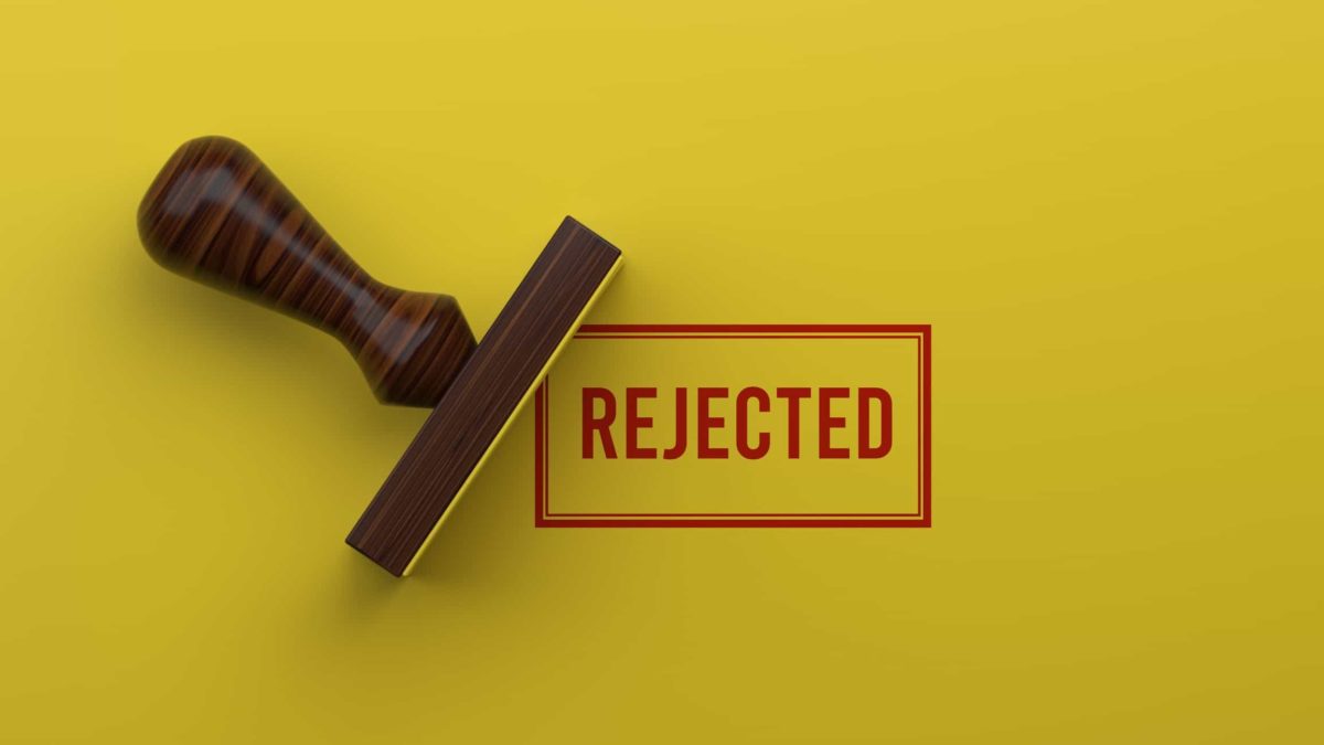 A rubber stamp stamping the word 'rejected' on a yellow background representing the highest bidder dropping out of the race to acquire Infomedia which is bringing its share price down today