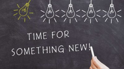 chalk drawing of light bulbs and the words 'time for something new' on a blackboard