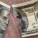 Boral share price divestment Banknote ripped in half, representing stock split.