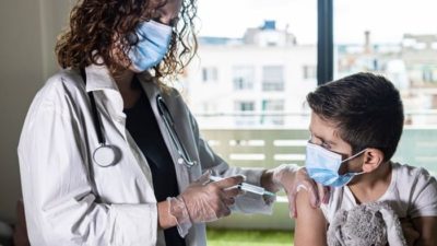 doctor giving little boy vaccine injection in his arm