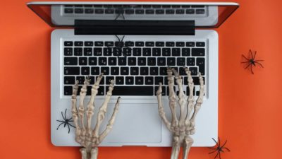 skeleton hands typing on laptop signifying that value investing is dead