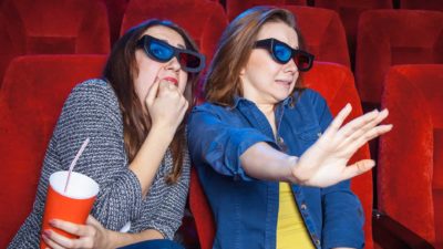 village share price lower represented by two women in cinema looking scared