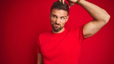 questioning whether asx share price is a buy represented by man in red shirt scratching his head