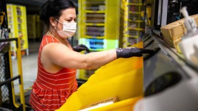 A worker processes Amazon products as the company adds more staff due to growing demand