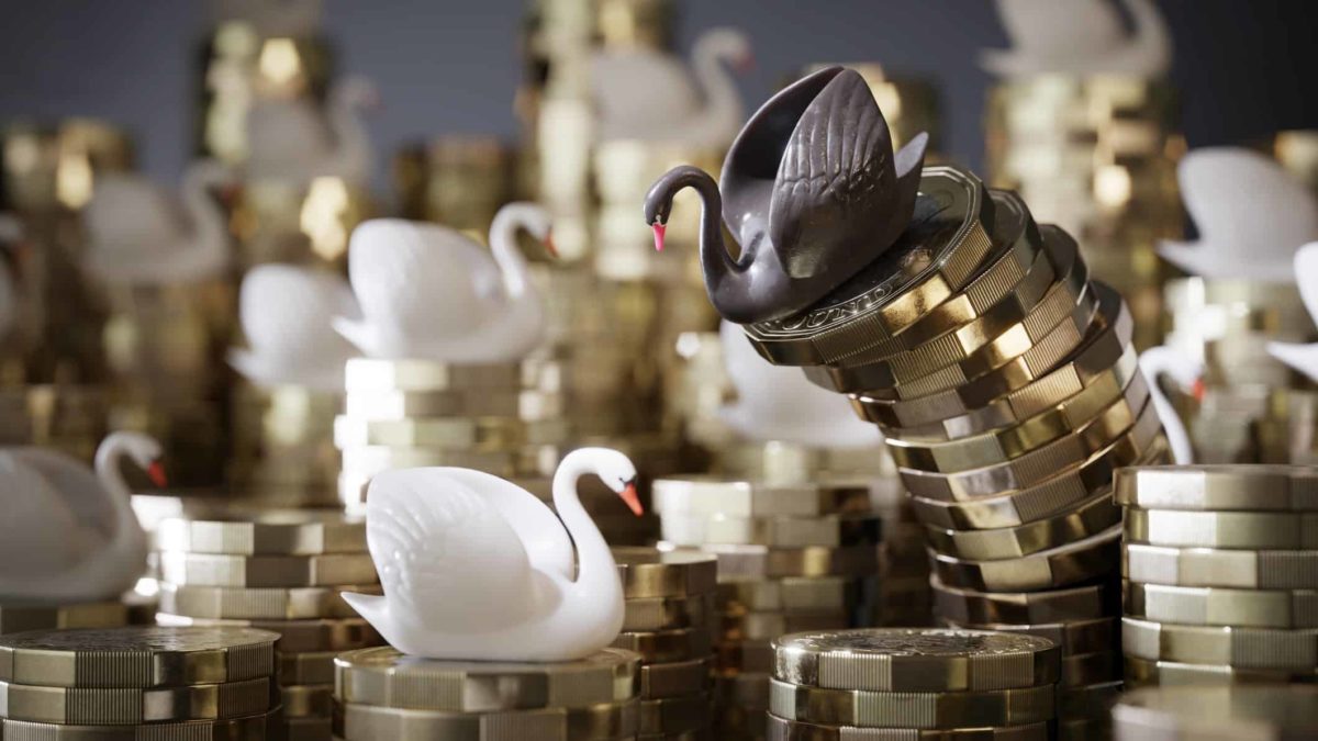 Black swan figurine on top of pile of coins started to topple over