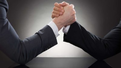 Arm wrestle between two men in business suits