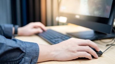 alphabet stock represented by man using Google search engine on computer