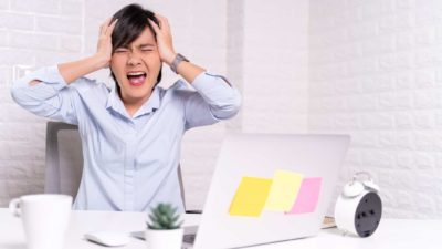 A woman putting her hands to her head grimaces and screams as the Zip share price plunges again